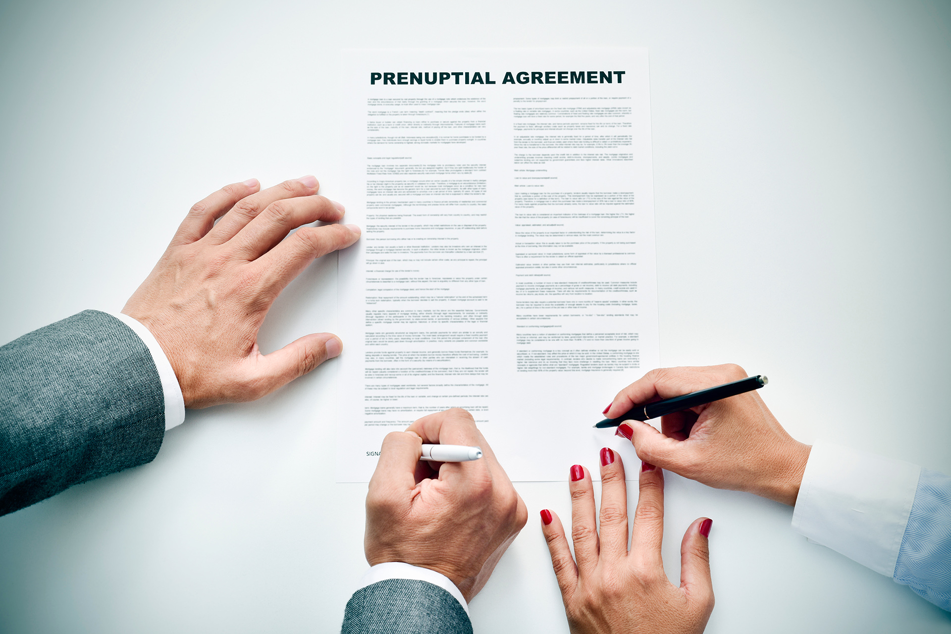 young man an woman signing a prenuptial agreement closeup of a young man an a young woman signing a prenuptial agreement